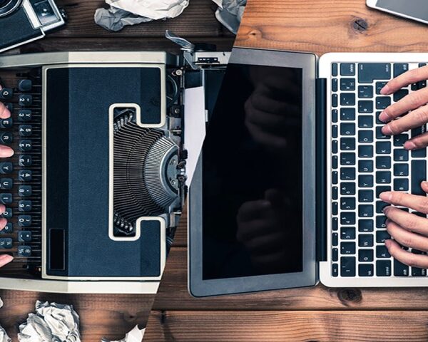 hands on a typewriter and laptop