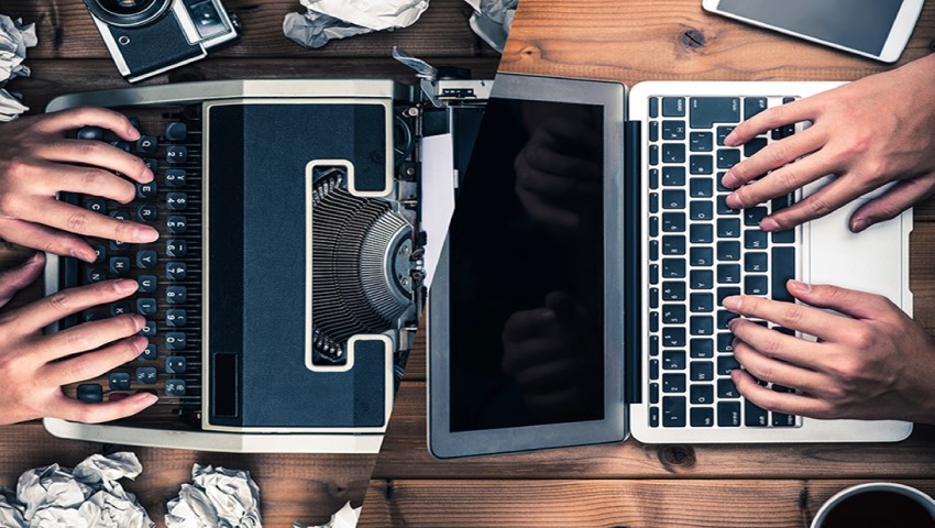 hands on a typewriter and laptop