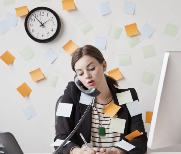 Image of a worried woman in the office with multiple tasks