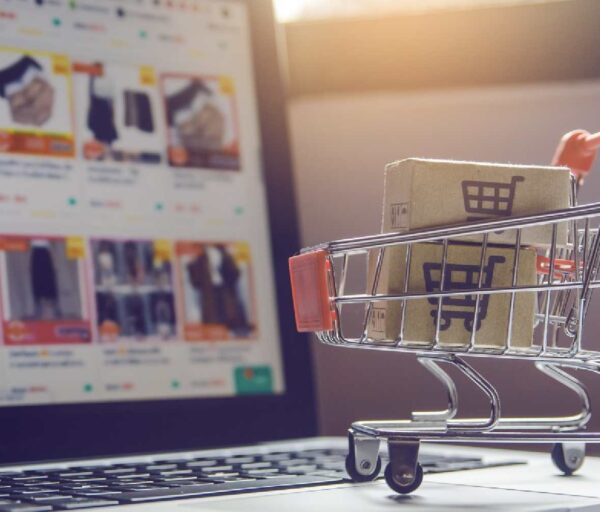 Image showing an e-commerce on a laptop screen with a shopping cart on the keyboard