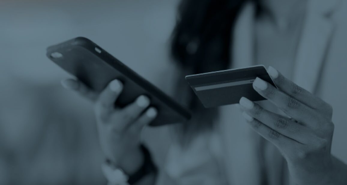 Woman with a cell phone and a credit card in her hand