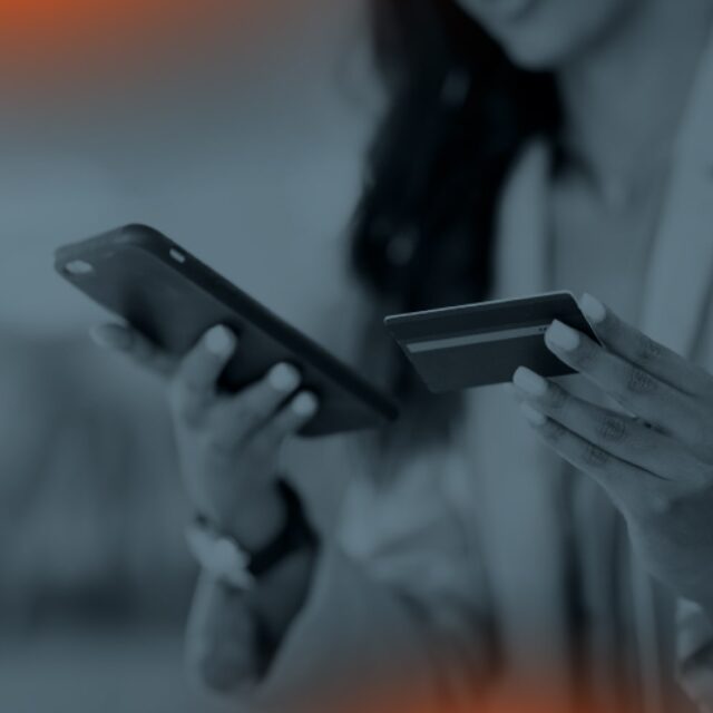 Woman with a cell phone and a credit card in her hand