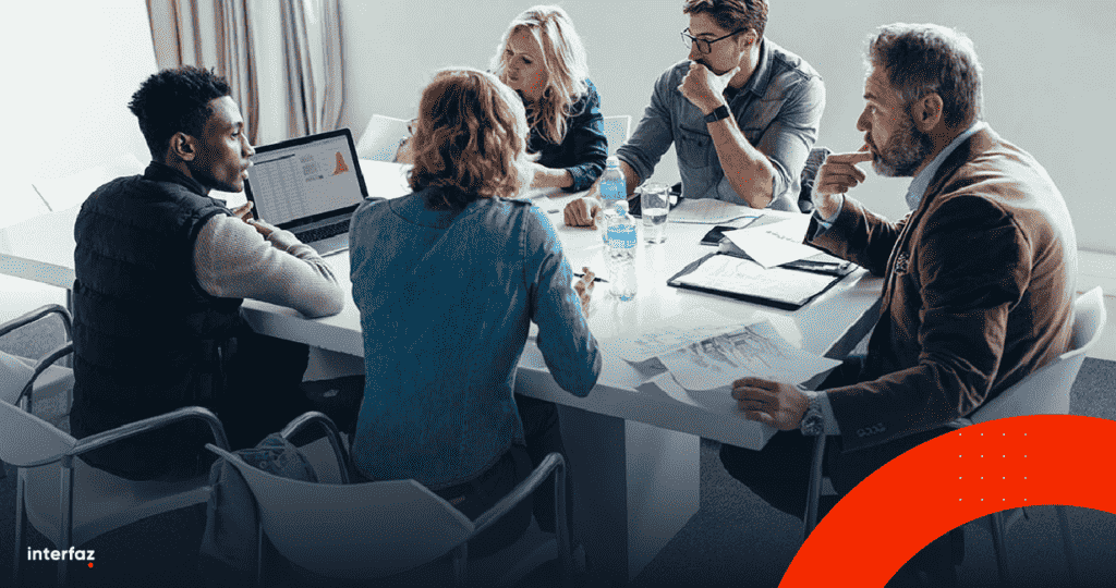 People gathered in a boardroom discussing a strategic technology plan