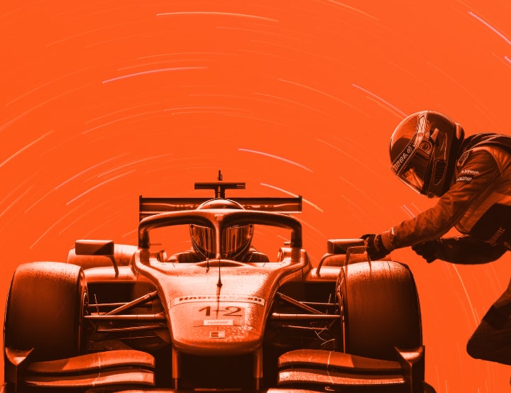Formula 1 driver with team member fueling the car
