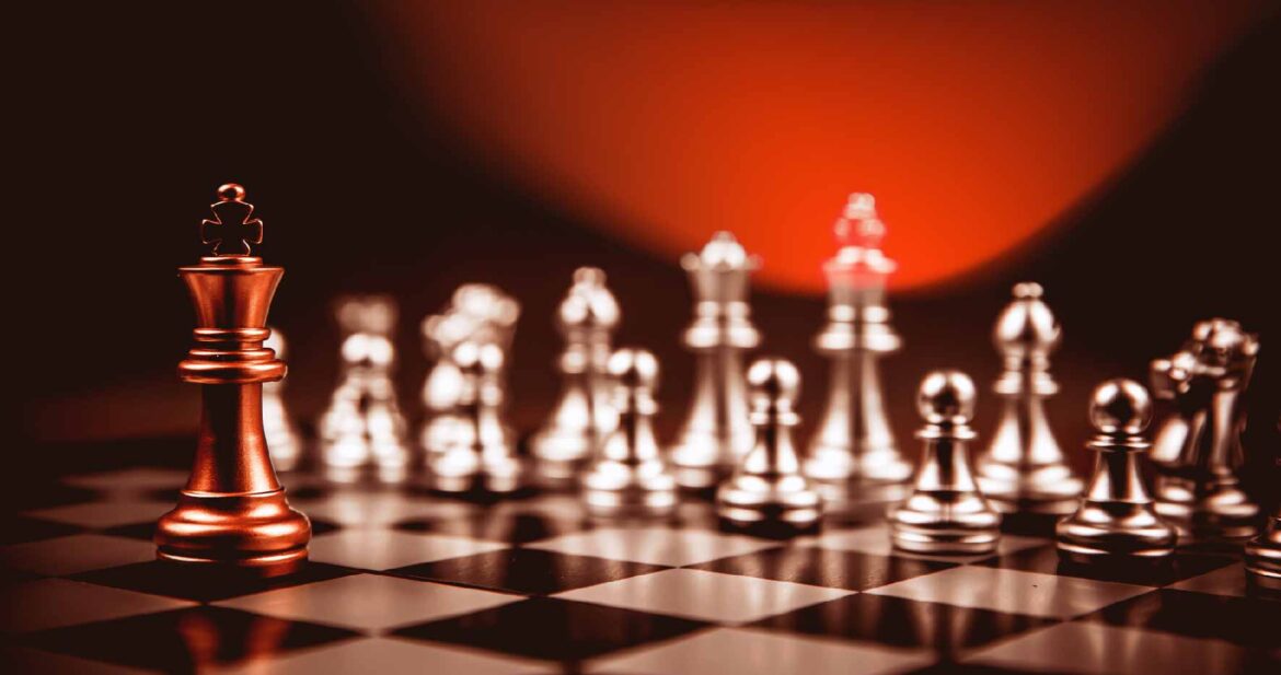 King golden chess standing confront of the silver chess team to challenge concepts of leadership and business strategy management